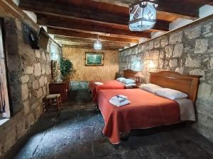 a bedroom with two beds in a stone wall at Hotel Casa del Anticuario in Morelia