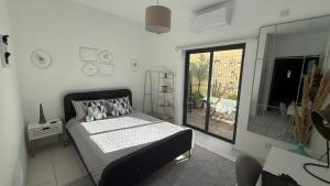 ein Schlafzimmer mit einem Bett und einem großen Fenster in der Unterkunft Happy Hive in Żejtun