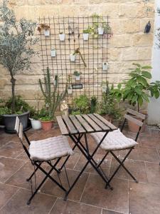 ein Picknicktisch und zwei Stühle in einem Garten in der Unterkunft Happy Hive in Żejtun