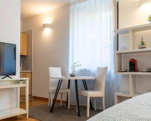 a room with a table and chairs and a television at Castello Living in Turin