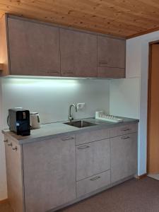 a kitchen with a sink and a counter top at Pension Staldacher in Hasliberg