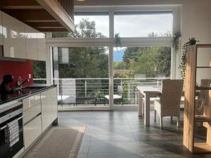 a kitchen with a table and a large window at Loft lumineux et confortable in Grimisuat
