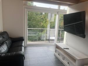 a living room with a couch and a large window at Loft lumineux et confortable in Grimisuat