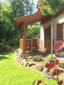 a wooden gazebo with a bench in a yard at Chalets-zum-Ilsetal-Jagd-Chalet-Nr-19 in Ilsenburg +8 photos