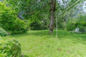 a park with a bench and a tree in the grass at Lykke Suite in Handewitt