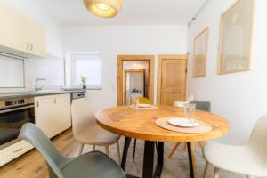 a kitchen with a wooden table and chairs in a room at Lykke Suite in Handewitt