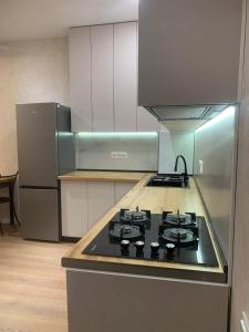 a kitchen with a stove and a refrigerator at E&L Apartment tbilisi in Tbilisi City