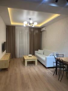 a living room with a white couch and a table at E&L Apartment tbilisi in Tbilisi City