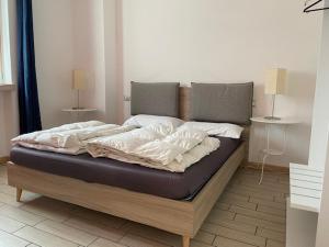 a large bed in a room with two lamps at Villa Gaia Apartments pool wifi parking in Malcesine