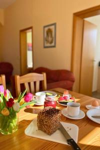 a wooden table with food and flowers on it at Bauernhuus 6 in Fehmarn
