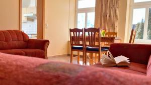 a living room with a couch and a table with a book at Bauernhuus 6 in Fehmarn