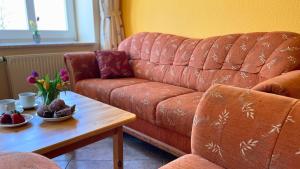 a living room with a couch and a table with flowers at Bauernhuus 4 in Fehmarn