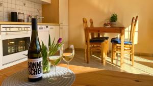 a bottle of wine sitting on a table with two glasses at Backhuus 2 in Fehmarn