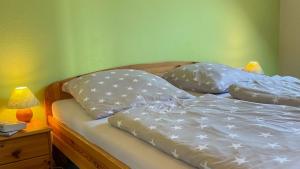 a bed with two pillows on it next to a lamp at Backhuus 2 in Fehmarn +34 photos