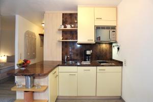 a kitchen with white cabinets and a counter top at Appartement 107 in Juist +41 photos