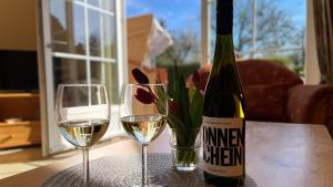 a bottle of wine and two glasses on a table at Backhuus 1 in Fehmarn