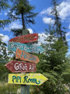 a street sign with many different signs on it at Boho Bungalow in Nelson