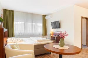 a hotel room with a bed and a table at Hotel Victoria in Hochheim am Main +8 photos