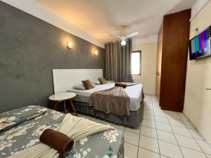 a hotel room with two beds and a table at GoHost Suítes - 2 Ruas do Shopping Santa Úrsula in Ribeirão Preto +47 photos