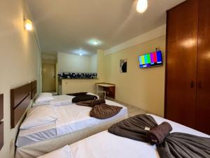 a group of three beds in a room at GoHost Suítes - 2 Ruas do Shopping Santa Úrsula in Ribeirão Preto