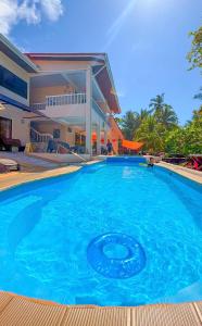 a large blue swimming pool in front of a house at Hotel Beachfront Vista Hermosa in Jacó