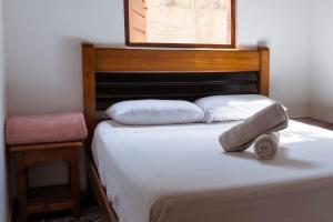 a bed with two pillows on it in a room at Casa Rosaz in Cavalcante
