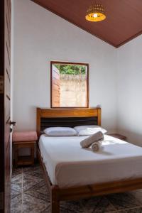 a bedroom with a large bed with a window at Casa Rosaz in Cavalcante