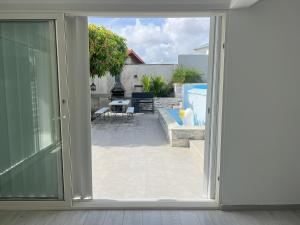 an open sliding glass door looking out onto a patio at Appartement Acajou Pool & Serenity in Le Lamentin