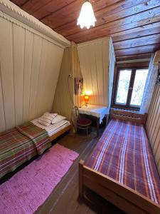 an attic room with two beds and a table at Ayur Garden Lanckorona in Lanckorona
