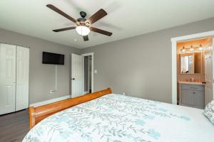 a bedroom with a bed with a ceiling fan at Blue Skies by Railey Vacations in Oakland +40 photos
