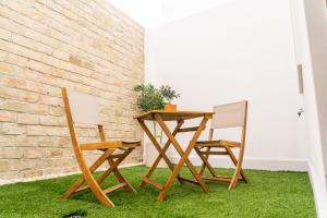 a table and two chairs sitting next to a brick wall at Pickman Suites in Seville