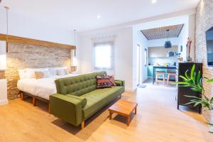 a living room with a bed and a green couch at Pickman Suites in Seville