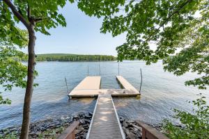 a dock in the middle of a lake with trees at Blue Stone Lodge by Railey Vacations in Swanton