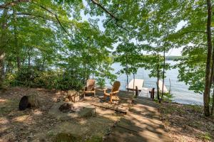 two chairs and a table on a dock near the water at Blue Stone Lodge by Railey Vacations in Swanton