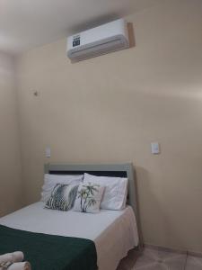 a bedroom with a bed with a air conditioner on the wall at Residence tropical, disponível 2 quartos para alugar in Guriú