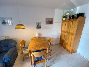 a living room with a wooden table and a blue couch at Hafenidylle-Orth-auf-Fehmarn in Orth