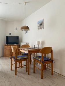 a dining room with a wooden table and chairs at Hafenidylle-Orth-auf-Fehmarn in Orth