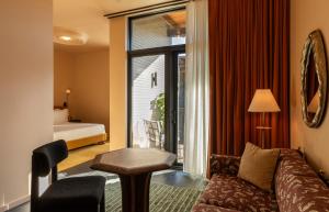 a living room with a couch and a bed and a window at Hotel Saint Augustine in Houston +65 photos
