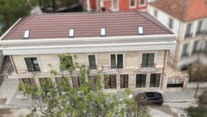 a large house with a roof on top of it at Post Inn Hotel-New Bazaar in Tirana