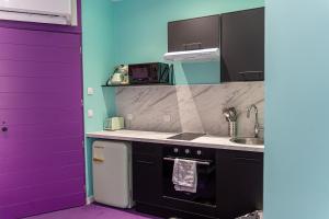 a kitchen with a purple door and a sink at Capsule Tattoo Love - Balnéo - Playstation 5 - écran géant in Douai