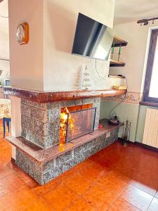 a stone fireplace with a tv on top of it at Casa di David in Cerete