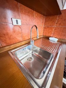 a stainless steel sink in a small kitchen at Casa di David in Cerete +30 photos