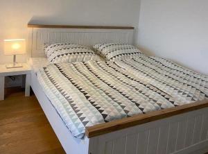 a bed in a bedroom next to a table with a lamp at Kaept-ns-Inn in Burgtiefe auf Fehmarn 