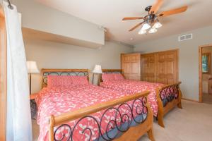 a bedroom with two beds and a ceiling fan at Boulder Creek Lodge by Railey Vacations in McHenry