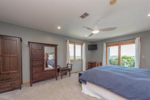 a bedroom with a bed and a dresser and a mirror at Boulder Creek Lodge by Railey Vacations in McHenry