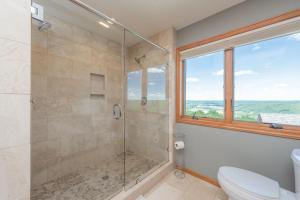 a bathroom with a shower and a toilet and a window at Boulder Creek Lodge by Railey Vacations in McHenry +42 photos