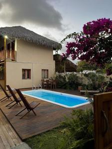 a swimming pool with two chairs and a house at suite elegante fullhausi 01 in Fortim