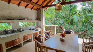 a kitchen with a table and chairs and a large window at Jungle Cottage in Tangalle
