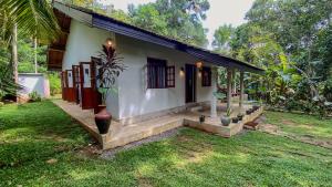 a house with a staircase leading to the front of it at Jungle Cottage in Tangalle