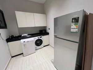 a kitchen with a refrigerator and a washing machine at جده شارع صاري in Jeddah